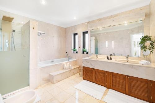 a large bathroom with a tub and a sink and a tub at Seafront View next to the famous “Benagil Caves” in Benagil