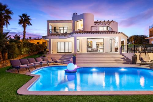 a villa with a swimming pool in front of a house at Seafront View next to the famous “Benagil Caves” in Benagil