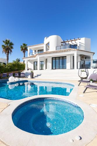 a house with a swimming pool in front of a house at Seafront View next to the famous “Benagil Caves” in Benagil