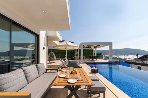 a living room with a couch and a table next to a pool at Tashan Villas in Kas