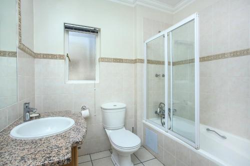 y baño con aseo, lavabo y ducha. en The Melrose Kernick Avenue Apartment, en Johannesburgo
