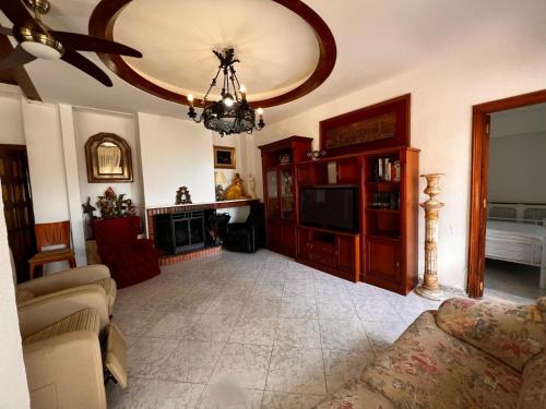 a living room with a couch and a chandelier at Villa Lazaro in Alfacar
