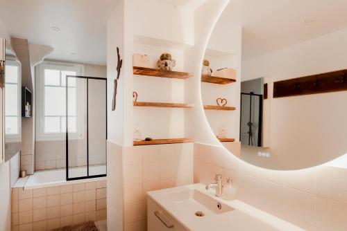 uma casa de banho com um lavatório e um espelho em Paris Trocadero Elegant Residence em Paris