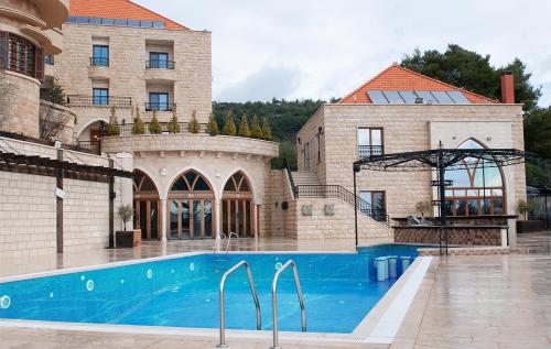 una casa con piscina frente a un edificio en L'auberge des Emirs, en Dayr al Qamar