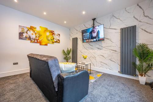 a living room with a tv on a stone wall at *RA10W* For your most relaxed & Cosy stay + Free Parking + Free Fast WiFi * in Belle Isle
