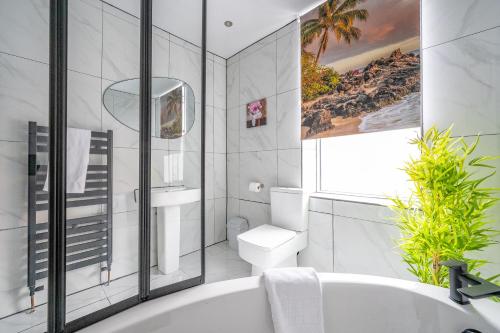 uma casa de banho branca com uma banheira e um WC em *RA10W* For your most relaxed & Cosy stay + Free Parking + Free Fast WiFi * em Belle Isle