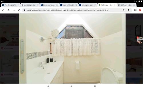 La salle de bains est pourvue d'une fenêtre, d'un lavabo et de toilettes. dans l'établissement Quiet and peaceful Perth City living with free Parking, à Perth