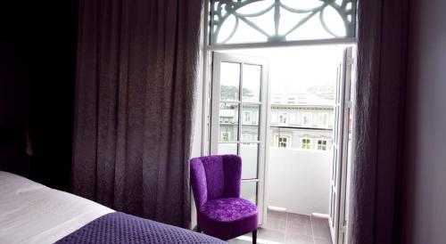 a purple chair sitting in front of a window at Hotel Oleana in Bergen