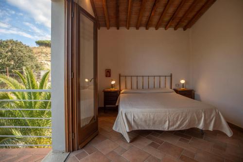 a bedroom with a bed and a large window at Appartamenti Mandorlo e Melograno by HelloElba in La Guardia