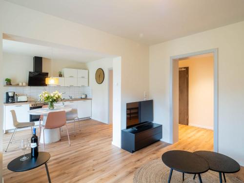 a living room with a table and chairs and a kitchen at Domizil am Gohrisch in Kurort Gohrisch