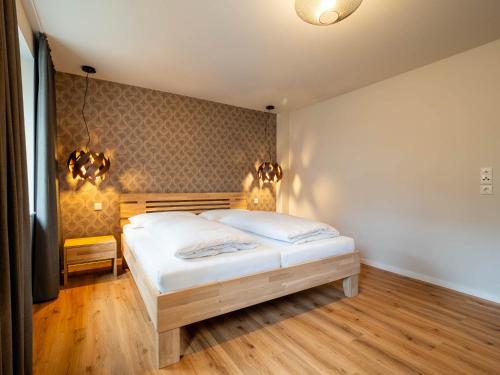 a bedroom with a bed and two lights on the wall at Domizil am Gohrisch in Kurort Gohrisch