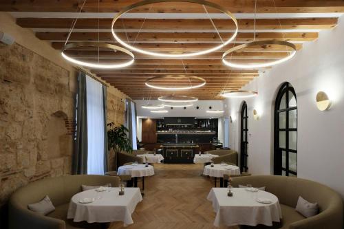 un restaurant avec des tables et des chaises et un lustre dans l'établissement Eunice Hotel Gastronómico, à Salamanque