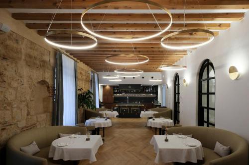a restaurant with tables and chairs and a chandelier at Eunice Hotel Gastronómico in Salamanca
