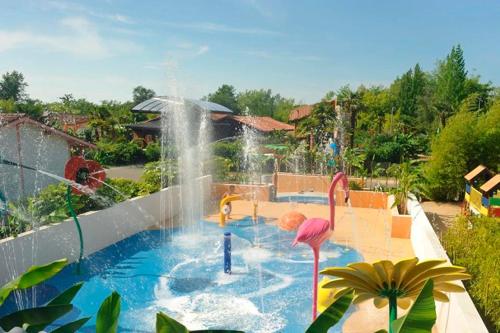 una piscina con un parque acuático con una fuente en Kampaoh Mézos en Mézos