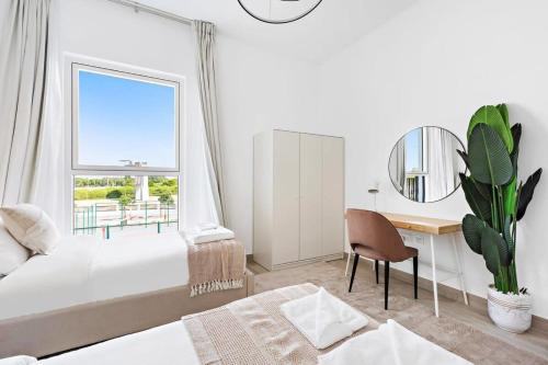 1 dormitorio con cama, escritorio y ventana en Silkhaus Close to Ferrari World Abu Dhabi, en Al Qurayyah
