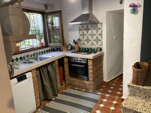 a kitchen with a sink and a stove top oven at Casa Franci in Granada