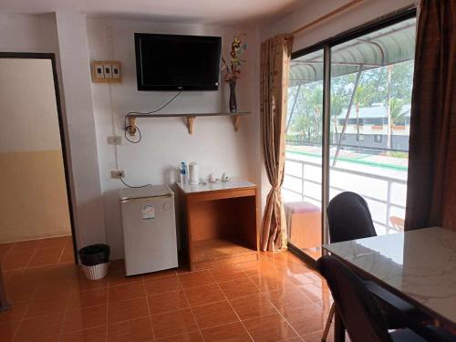 uma sala de estar com um pequeno frigorífico e uma televisão em Patong Rose Guest House em Patong Beach