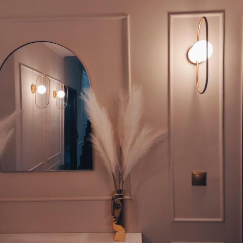 a bathroom with a mirror and a vase with feathers at L Suites The Writer's House in Gythio