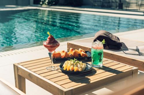 ein Tablett mit Essen auf einem Tisch neben dem Pool in der Unterkunft Hotel Estefania Boutique Suites in Los Cristianos