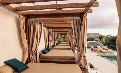 a row of beds on a balcony next to a pool at Hotel Estefania Boutique Suites in Chayofa