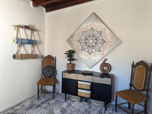 una stanza con due sedie e un comò e una foto sul muro di Getaway to Relax & Play at Meraki ad Agios Stefanos