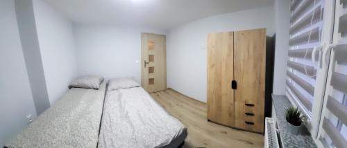 um quarto com uma cama e uma porta de madeira em ApartHotel em Bystrzyca Kłodzka
