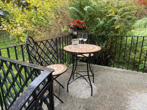 a table with two chairs and wine glasses on a fence at Kvammen in Sæbø