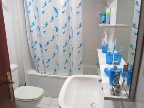 フォスにあるApartamento en Foz Entreplayasのバスルーム(洗面台、トイレ、シャワーカーテン付)