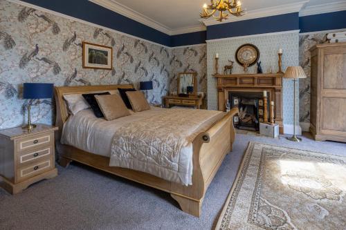 a bedroom with a large bed and a fireplace at Highgate House in Whitby