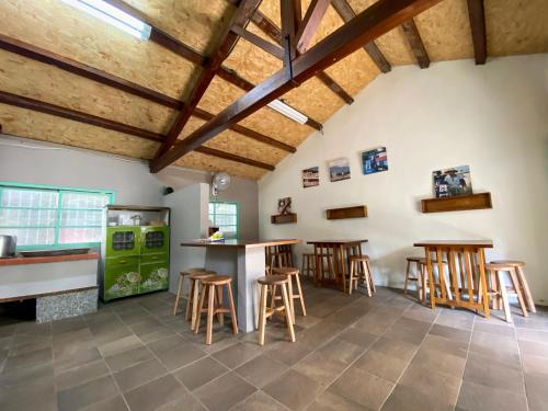 Una habitación con taburetes de madera y una cocina con un refrigerador verde. en 楊桃墅民宿, en Chishang
