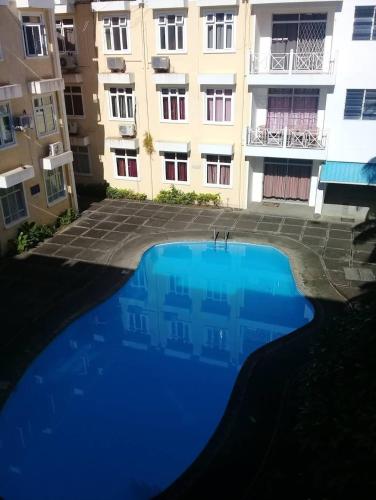 a large blue swimming pool in front of a building at Le Residence Blue Bay in Blue Bay
