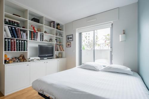 une chambre blanche avec un lit et une fenêtre dans l'établissement Veeve - Aligre Heights, à Paris