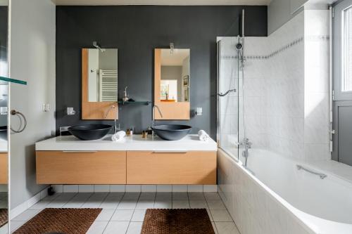 une salle de bain avec deux lavabos et une douche dans l'établissement Veeve - Aligre Heights, à Paris