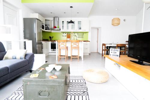 un salon avec un canapé, une table et une cuisine dans l'établissement Appartement rez de chaussée au cœur de la Chaume 4 personnes Les Sables, à Les Sables-dʼOlonne