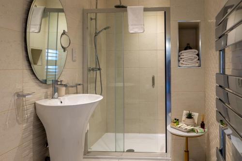 a bathroom with a shower and a sink and a mirror at Highgate House in Whitby