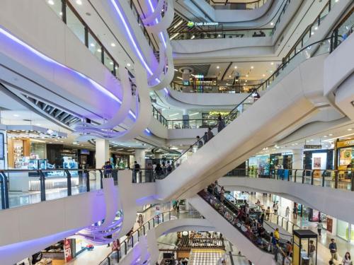 a shopping mall with escalators and people in it at 420 House- up to 10 guests in central Bangkok. in Bangkok