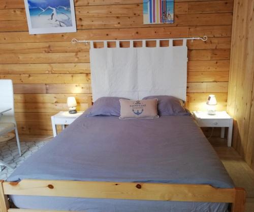 ein Schlafzimmer mit einem Bett in einer Holzhütte in der Unterkunft CHAMBRE LA NOE in Saint-Cast-le-Guildo