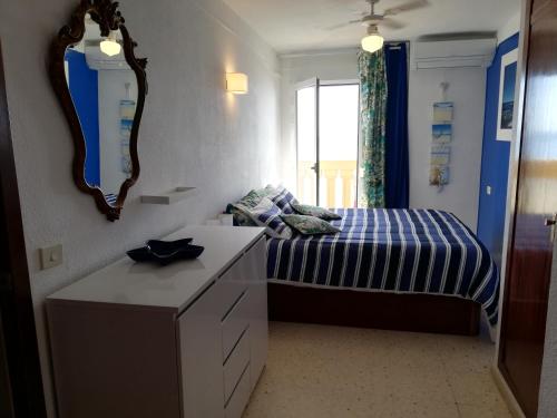 - une petite chambre avec un lit et un miroir dans l'établissement IDEALLY located on BEACH, à Port Saplaya