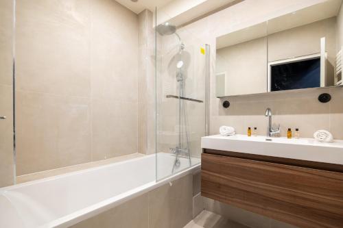une salle de bain avec une baignoire, un lavabo et une douche dans l'établissement Veeve - Footsteps From Trocadéro, à Paris