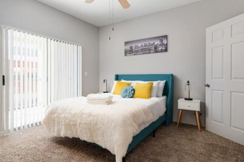 a bedroom with a blue bed with yellow pillows at Corporate Housing by MGM in Farmers Branch