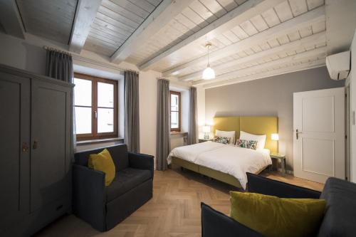 1 dormitorio con 1 cama y 1 sofá en Bogen bistro & apartments, en Bolzano