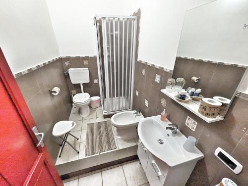 Un baño con inodoro, lavabo y espejo. en B&B Villareale 35, en Palermo