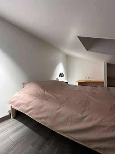 um quarto com uma cama grande numa parede branca em Triplex Vieux bourg em Chauvigny