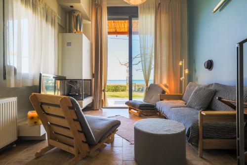 a living room with a couch and a tv at Pelagos Paradise Seafront Villa by Booking Kottas in Kalamitsi