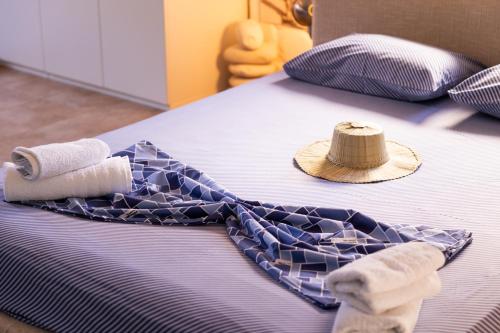 a bed with two towels and a hat on it at Pelagos Paradise Seafront Villa by Booking Kottas in Kalamitsi