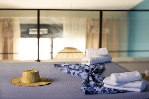 a table with towels and a straw hat on it at Pelagos Paradise Seafront Villa by Booking Kottas in Kalamitsi