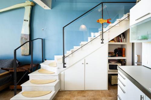 a staircase in a room with a blue wall at Pelagos Paradise Seafront Villa by Booking Kottas in Kalamitsi