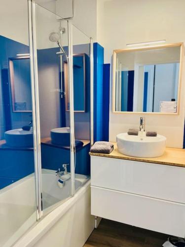 une salle de bain bleue avec un lavabo et un miroir dans l'établissement ''Le Phare''grand T3 vue imprenable sur le port et la mer !, à Sète