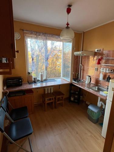 une cuisine avec un comptoir et une grande fenêtre dans l'établissement Comfy, well-located flat in Green Agenskalns, à Riga