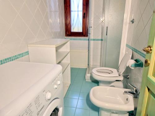 biała łazienka z toaletą i umywalką w obiekcie La Terrazza w mieście Villasimius